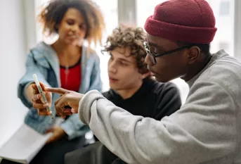 3 jeunes regardant le même smartphone