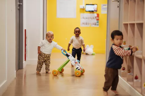 Des enfants jouent dans le couloir de leur crèche