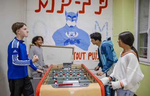 4 enfants qui jouent au babyfoot dans l'internat de Vitagliano à Marseille