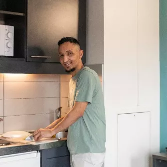 Un jeune résident prépare son repas au sein de la résidence sociale