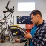 Jeune homme réparant un vélo dans l'atelier