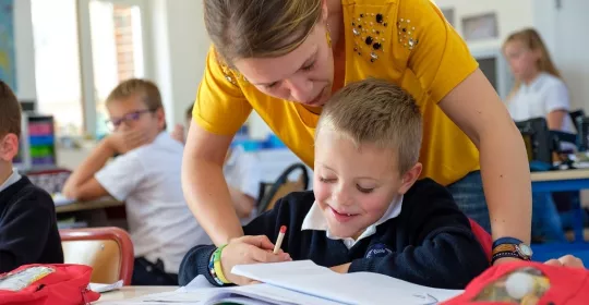 Une professeure des écoles travaille avec un jeune élève